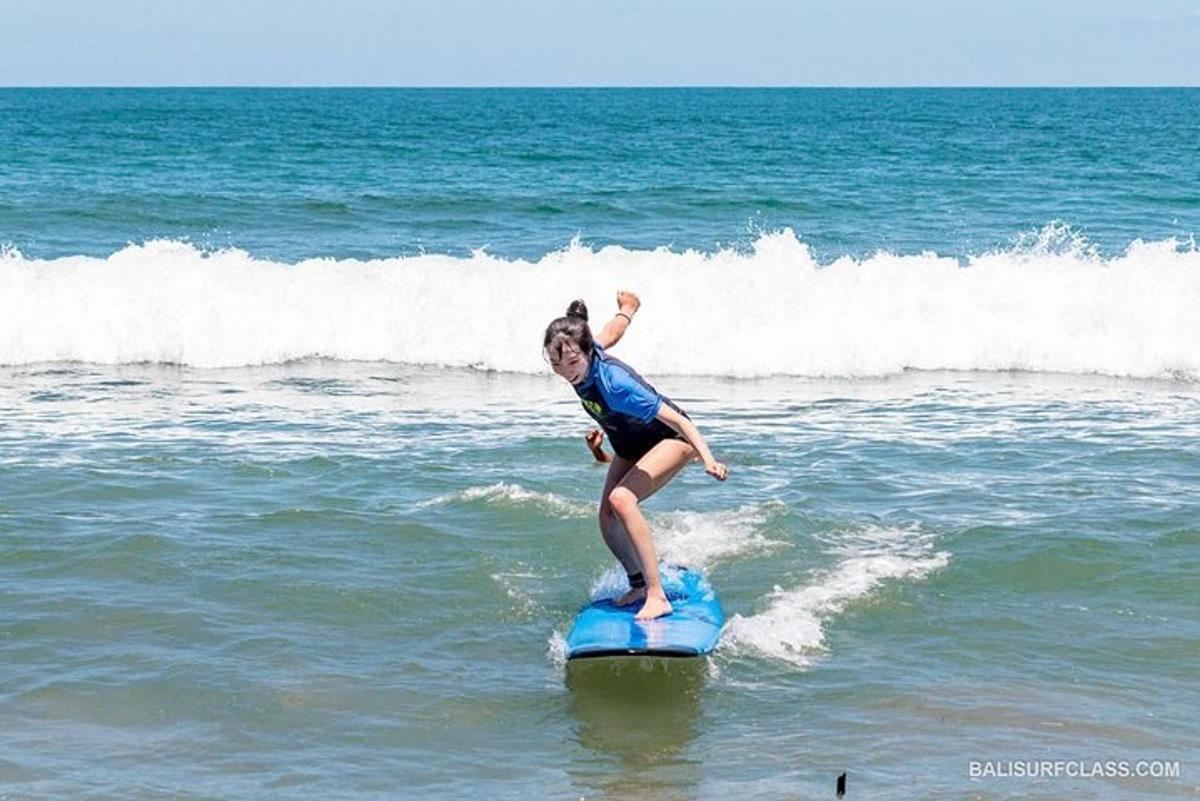 une jeune fille chevauchant une vague sur une planche de surf dans l'océan