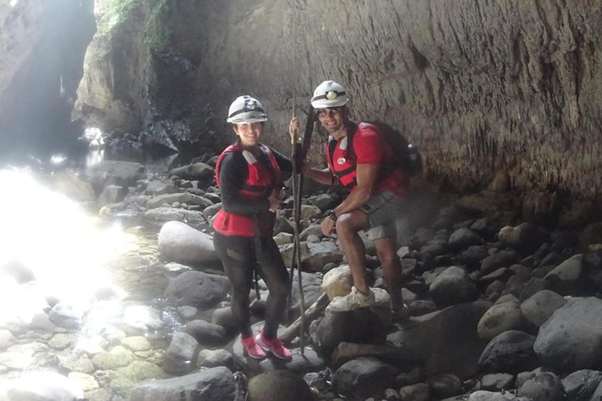 due persone sono in piedi sulle rocce in un fiume