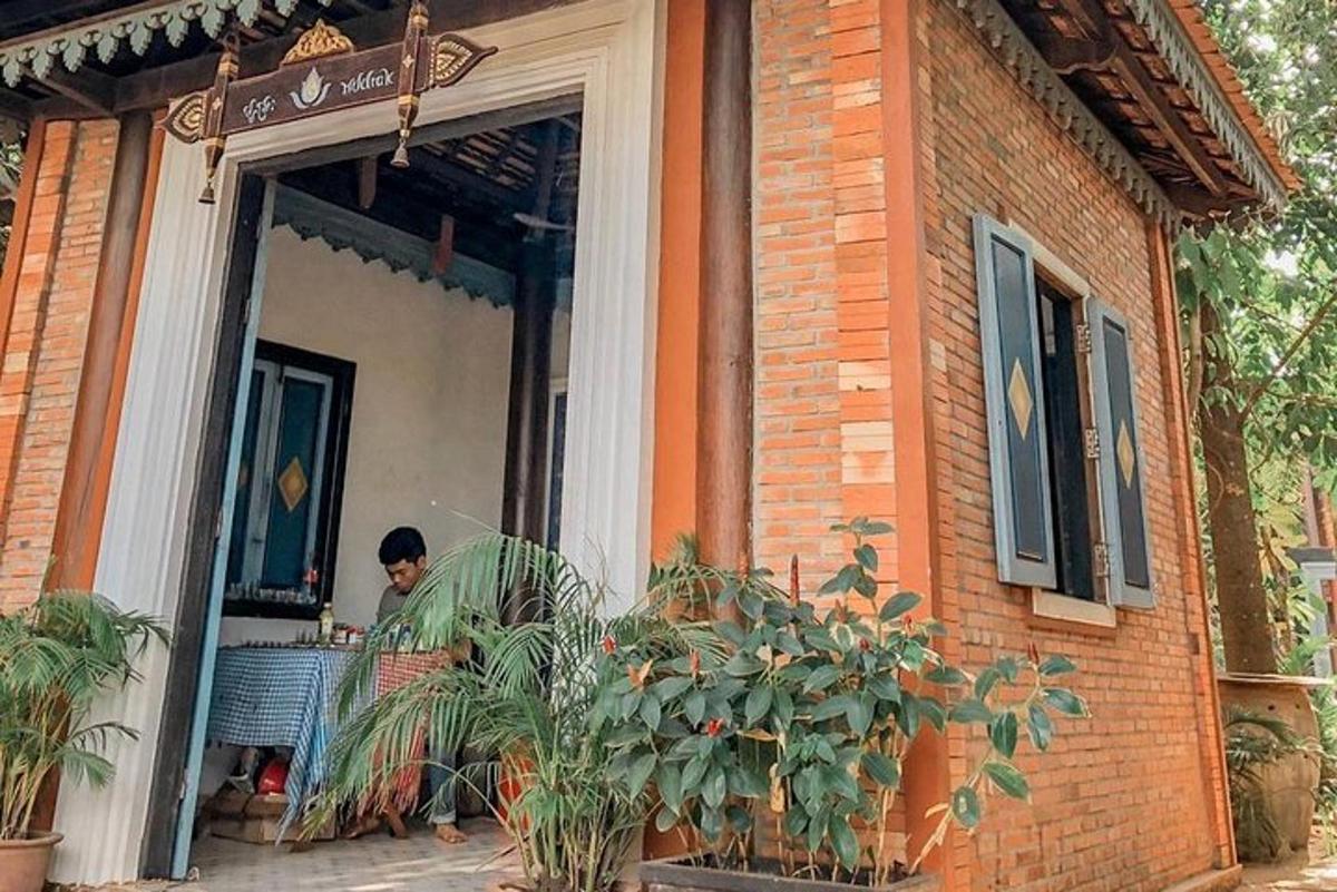 一名男子坐在建筑物外的桌子旁