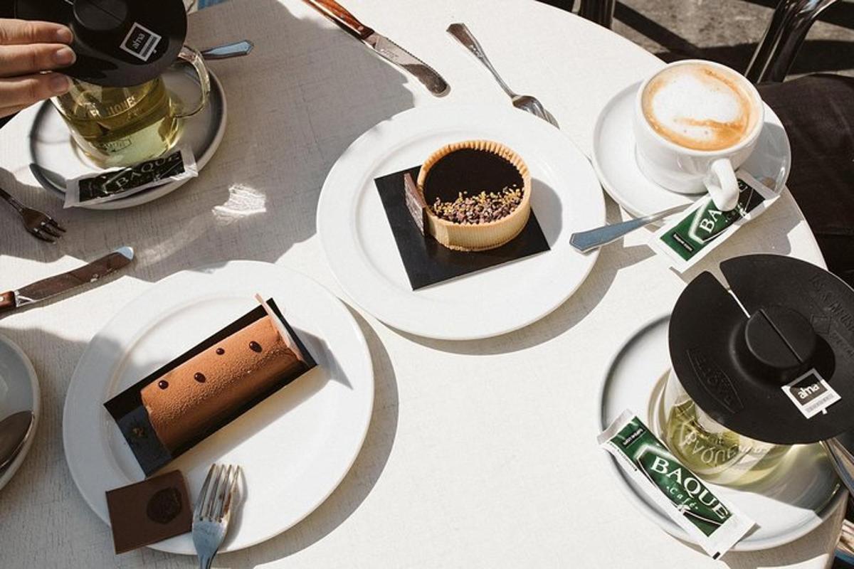 miza s krožniki torte in skodelico kave