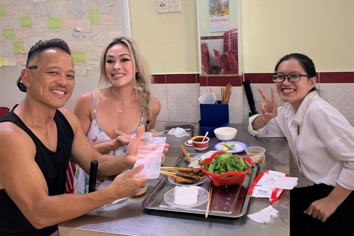 a group of people sitting at a table with food