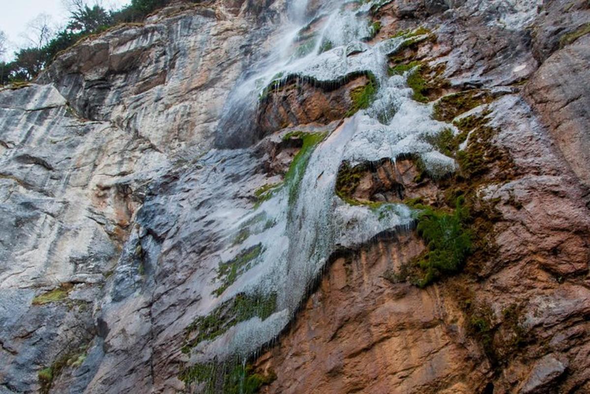 una cascada en la ladera de una montaña rocosa