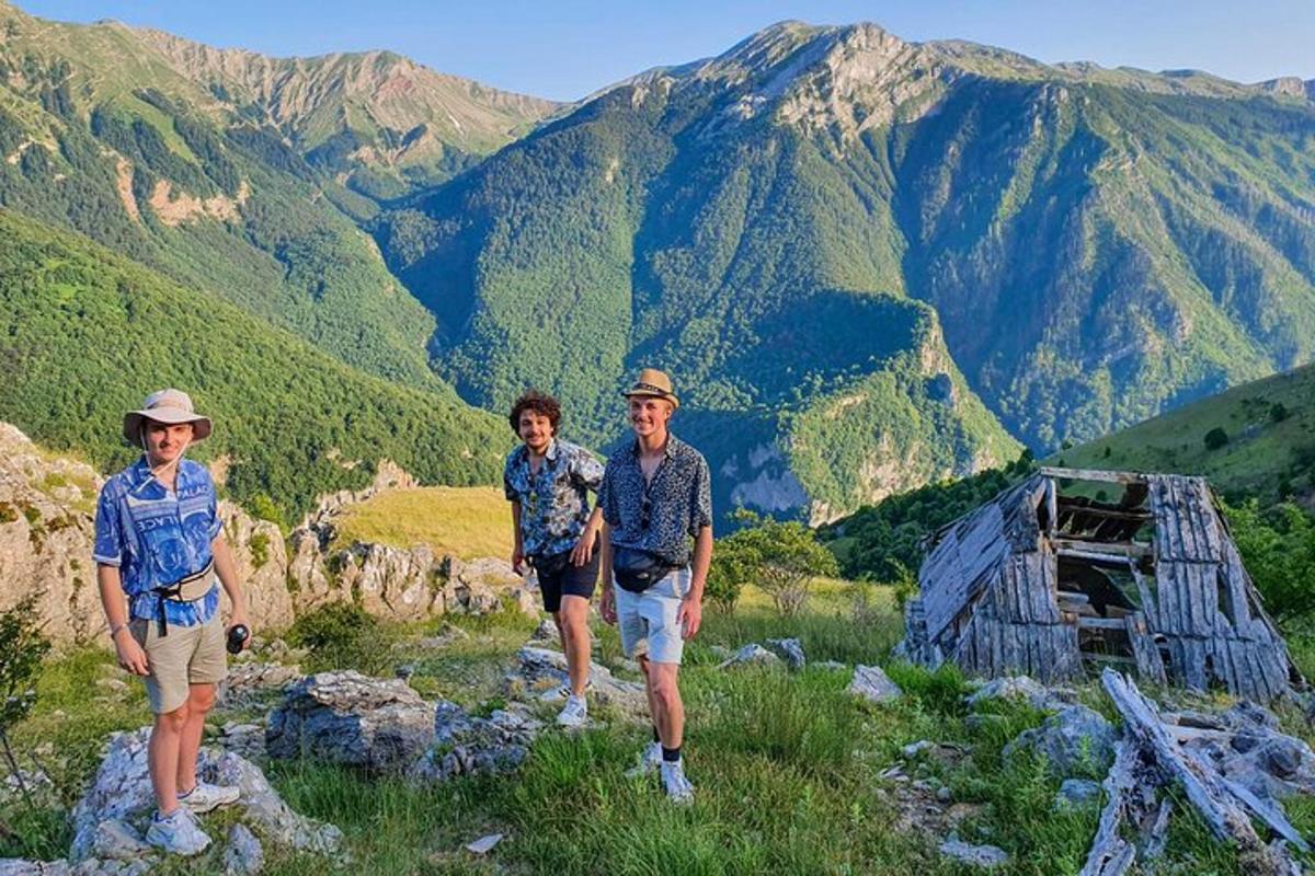 þrír menn standa á fjallstindi
