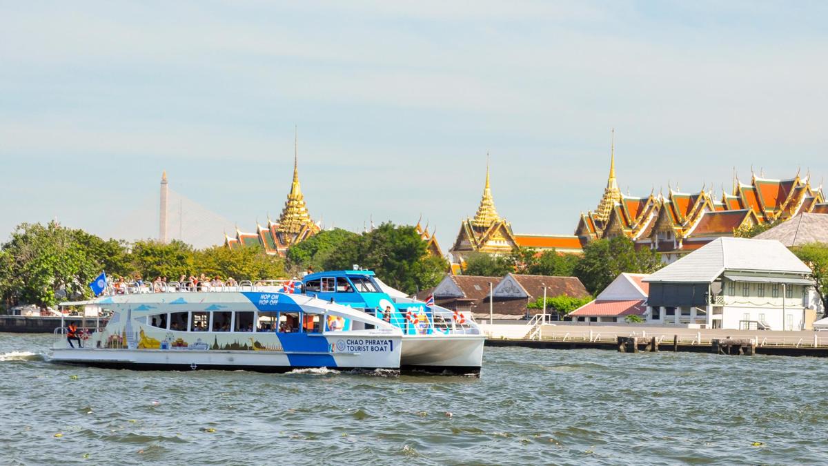 a blue and white boat in the water near a city