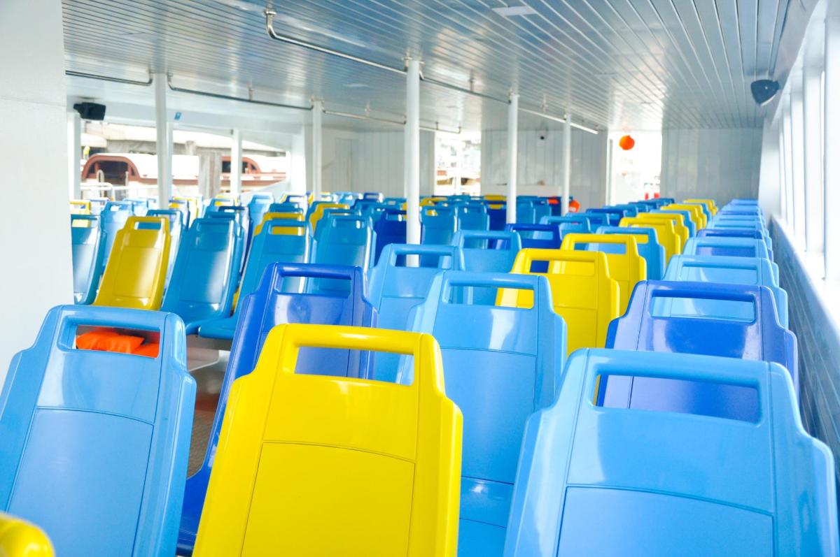 a row of blue and yellow seats on a bus