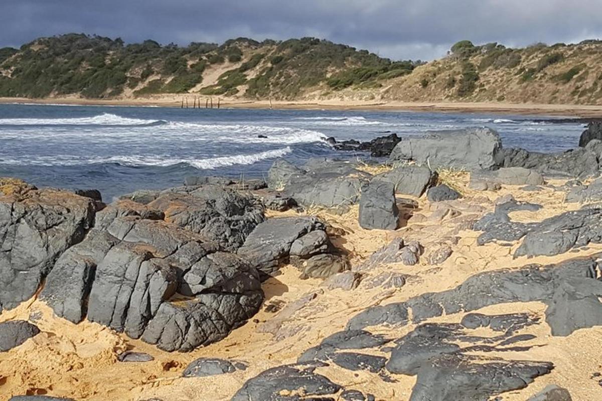 una spiaggia con rocce nella sabbia e l'oceano