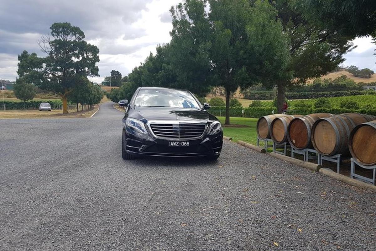 un'auto nera parcheggiata su una strada piena di barili