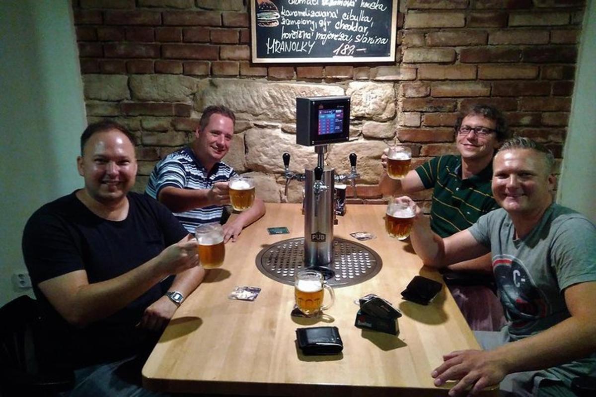 a group of men sitting around a table withints of beer