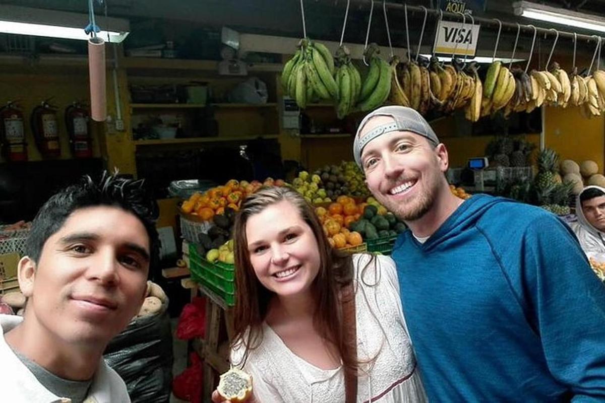 un gruppo di tre persone in piedi in un mercato ortofrutticolo