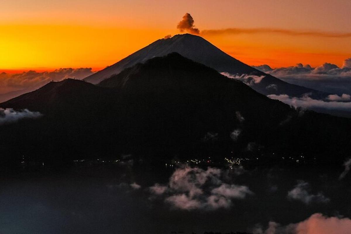 Una vista de una montaña con una puesta de sol al fondo.