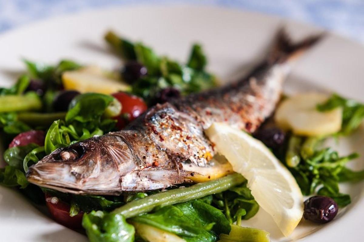 ein Teller mit Essen mit Fisch und Gemüse