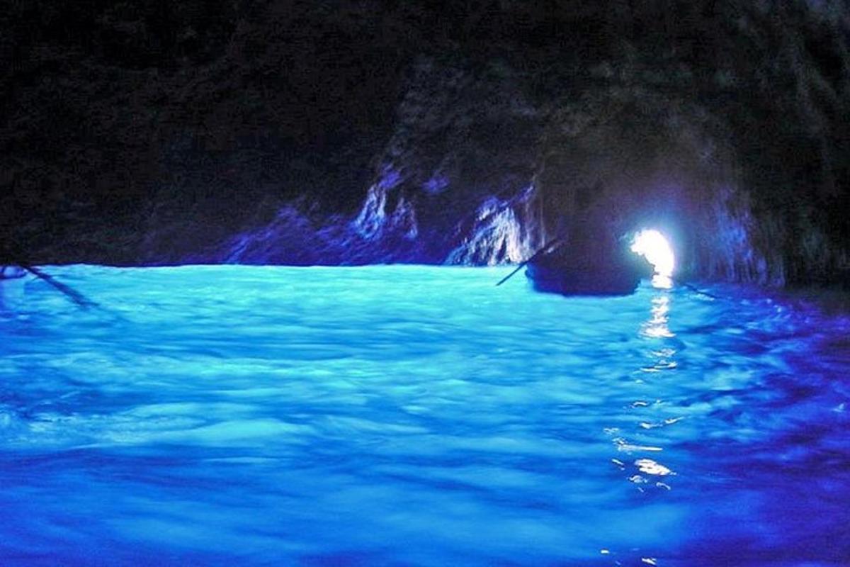 una grotta con acqua blu e una luce al suo interno