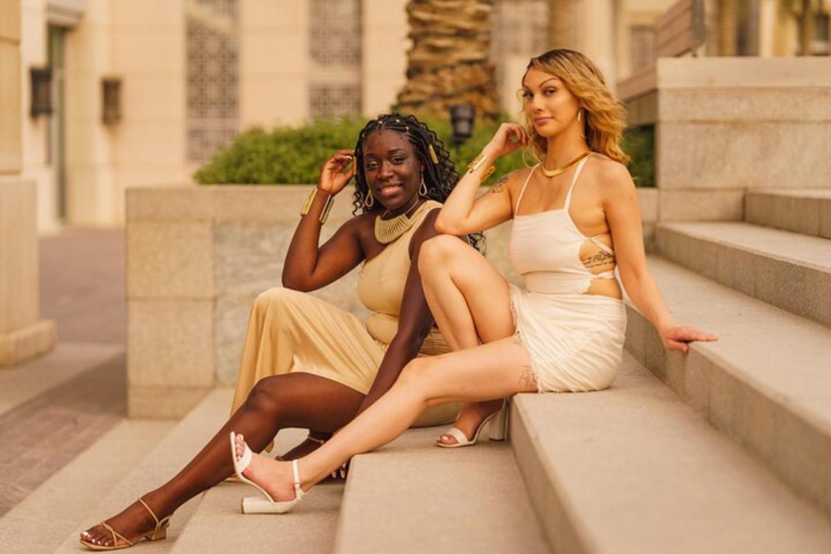 two women in dresses sitting on some steps