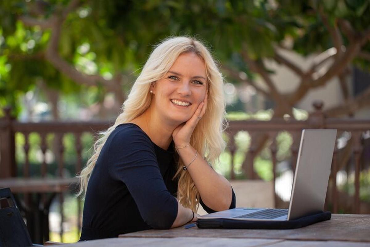a woman sitting at a table with a laptop