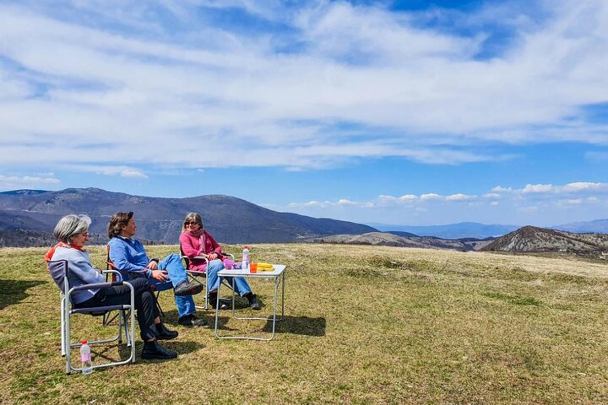 tre donne sedute a un tavolo in cima a una collina