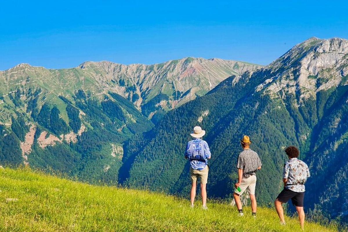 tre persone in piedi su una collina che guardano una montagna