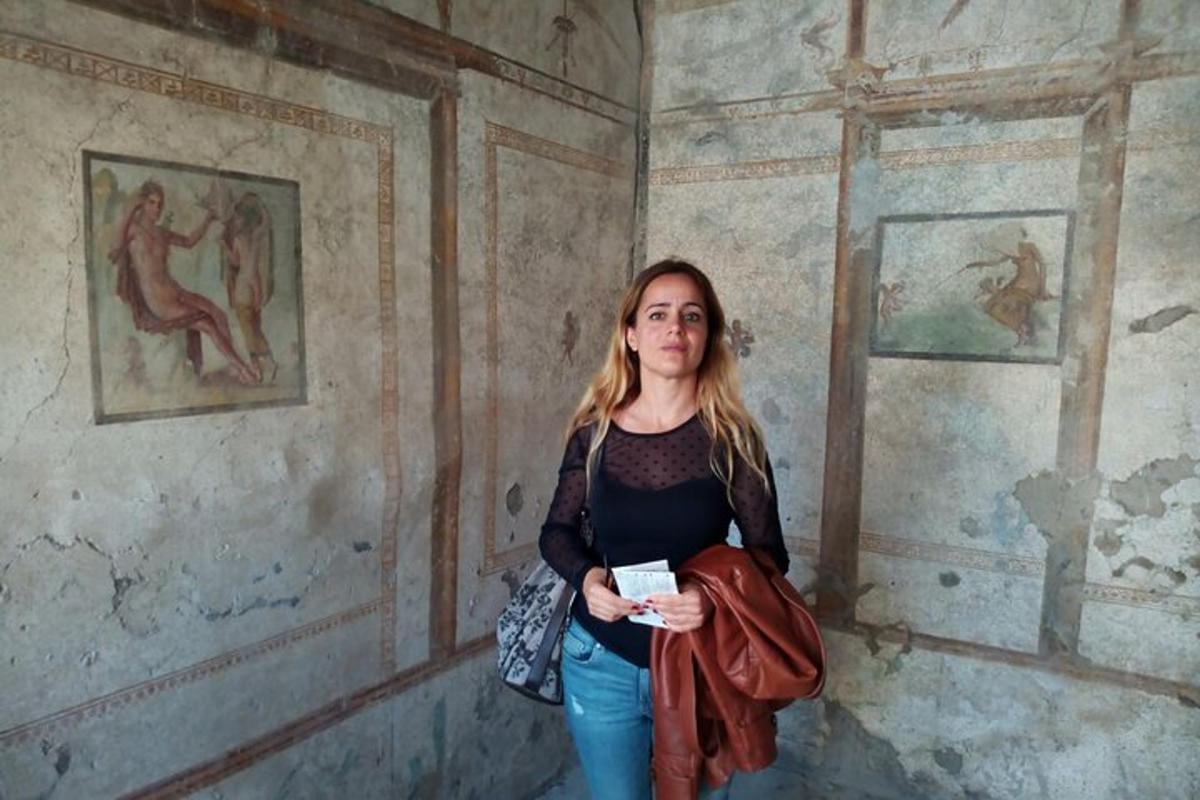 una donna in piedi in una stanza con dipinti alle pareti