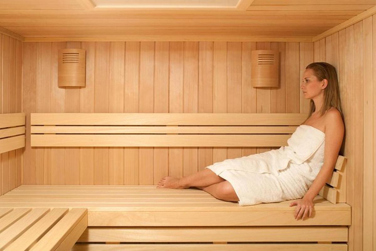 Una mujer está sentada en una sauna.
