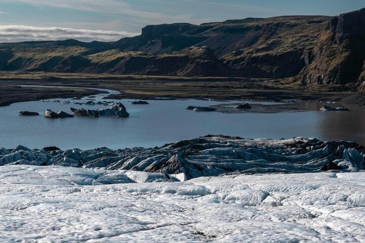 uma vista de um corpo de água com neve e montanhas