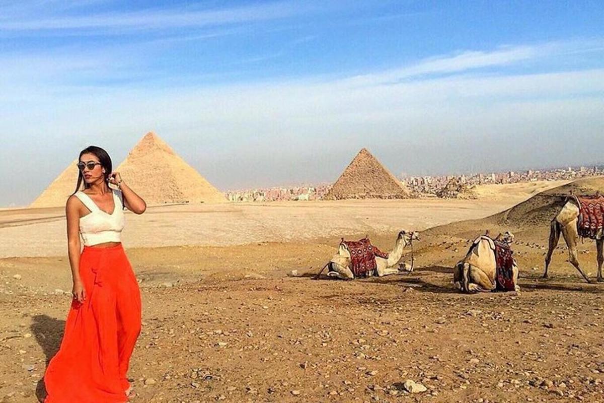 a woman is standing in front of the pyramids