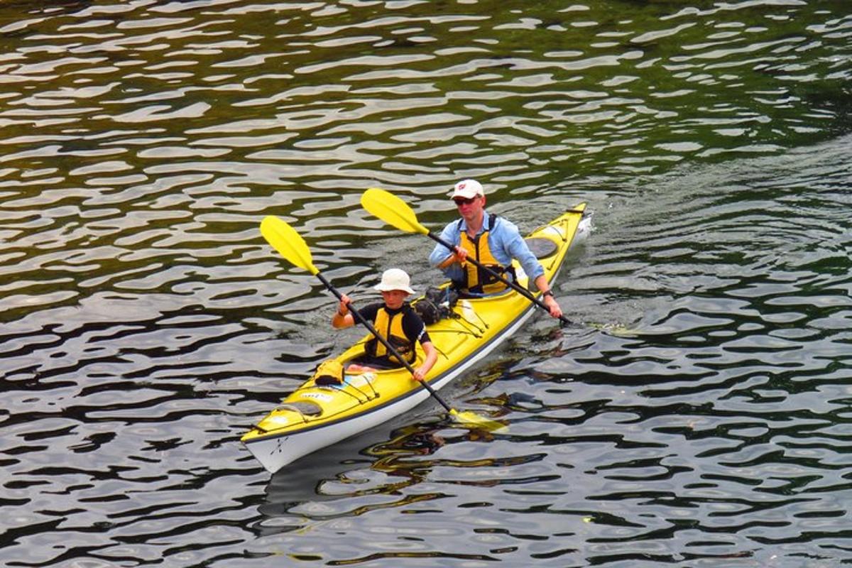 Dos personas en un kayak amarillo en el agua.