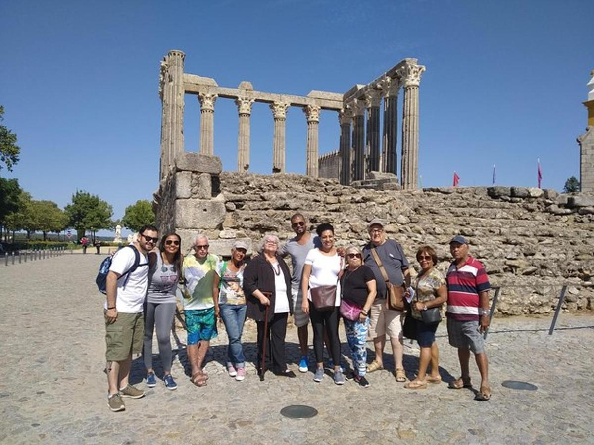 μια ομάδα ανθρώπων που στέκονται μπροστά σε έναν ναό