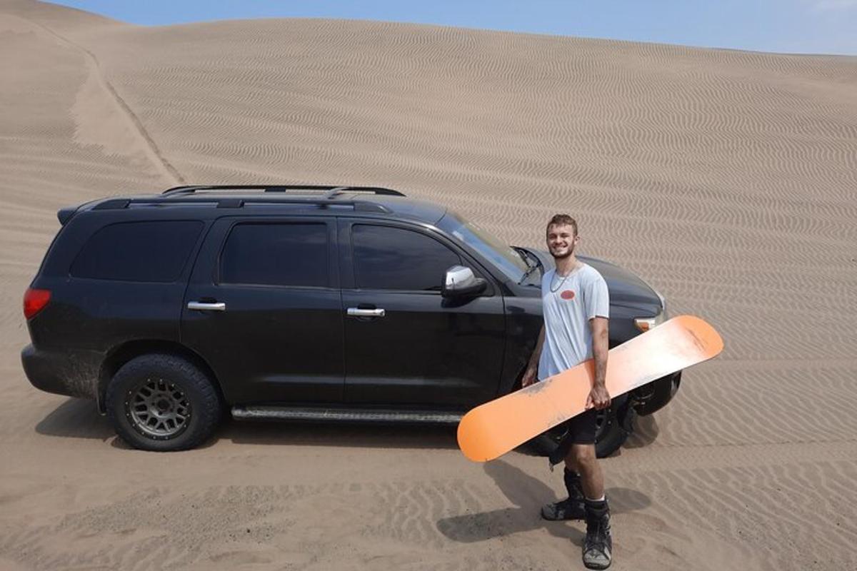 un uomo che tiene una tavola da surf davanti a un camion