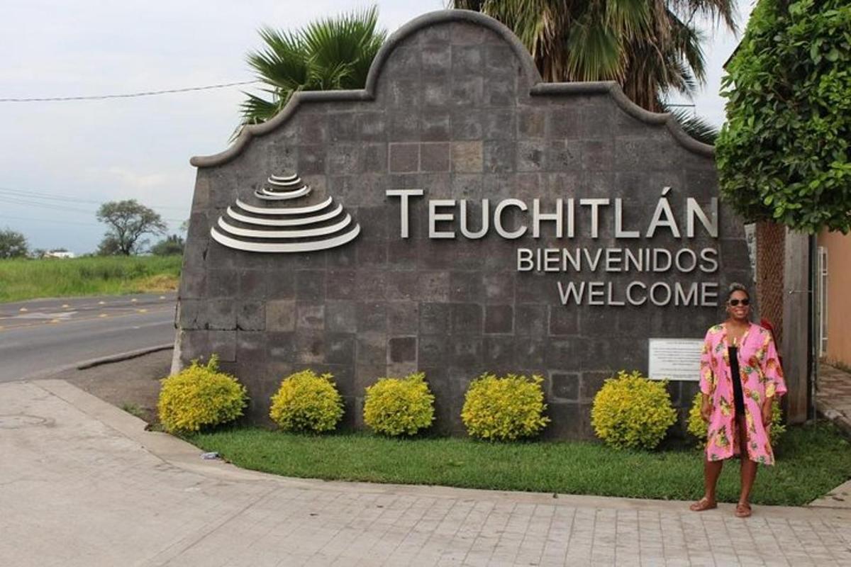 Una mujer parada frente a un cartel de bienvenida
