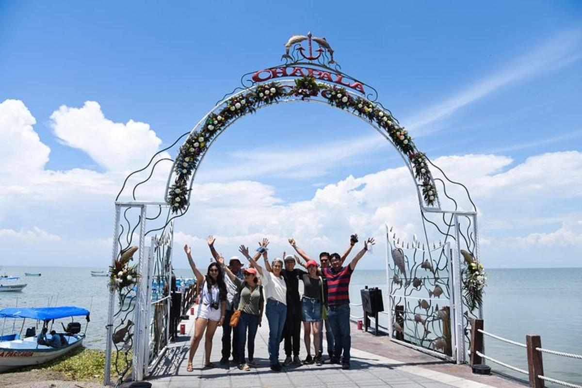 un gruppo di persone in piedi sotto un arco sulla spiaggia