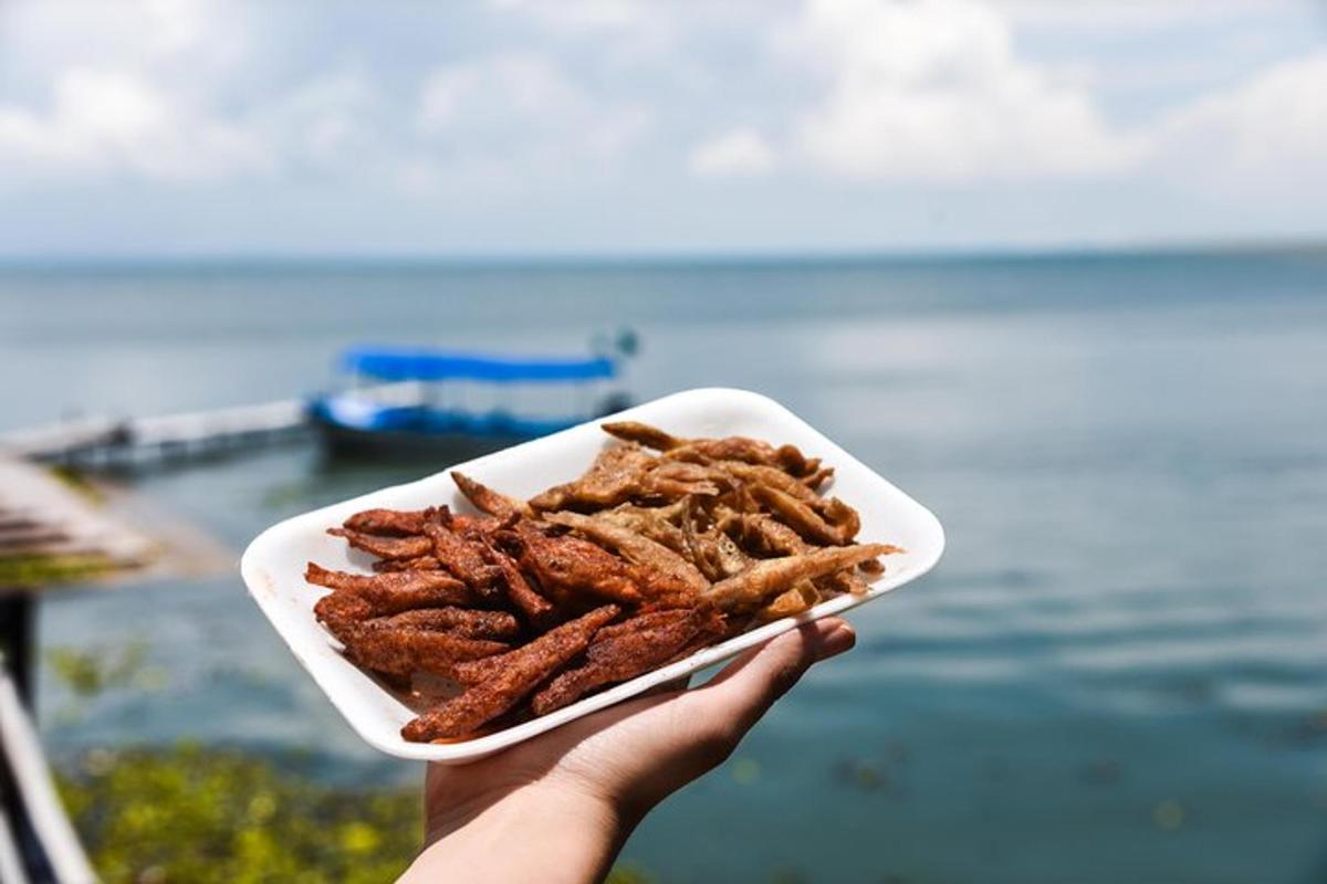 een persoon die een bord met eten voor de oceaan houdt