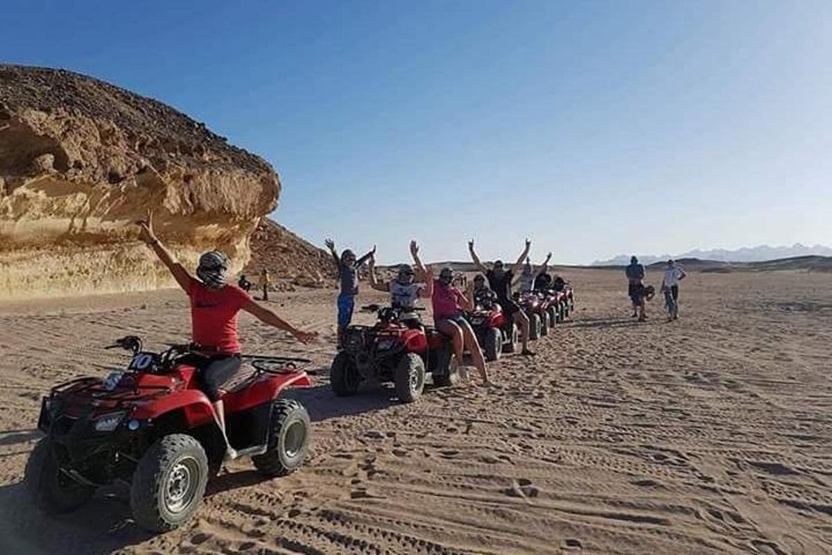 eine Gruppe von Leuten, die in der Wüste Geländefahrzeuge fahren