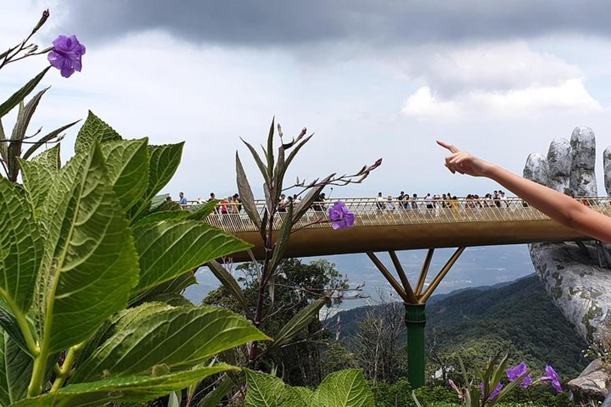 un gruppo di persone che attraversa un ponte sopra una montagna