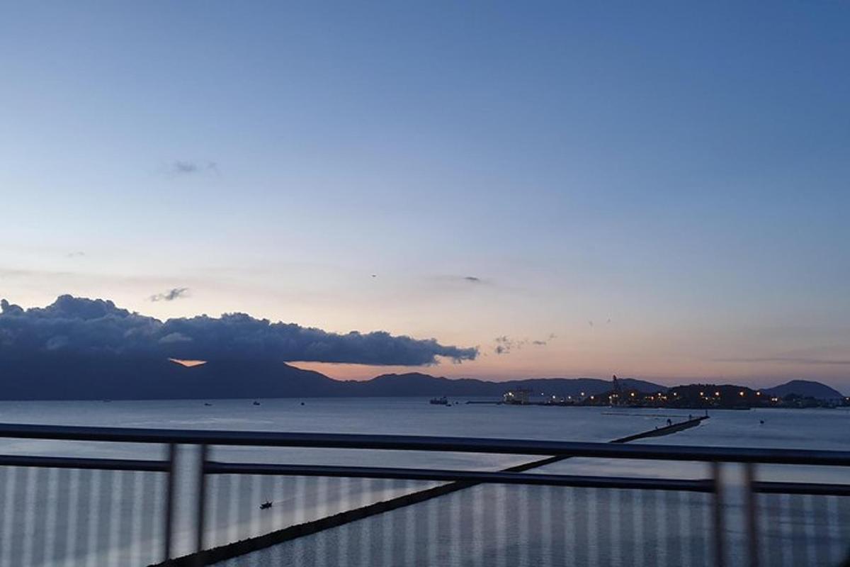 Una vista del océano con una puesta de sol de fondo.