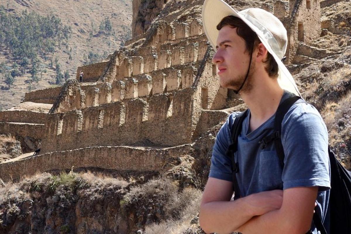 a man with a hat standing on a cliff