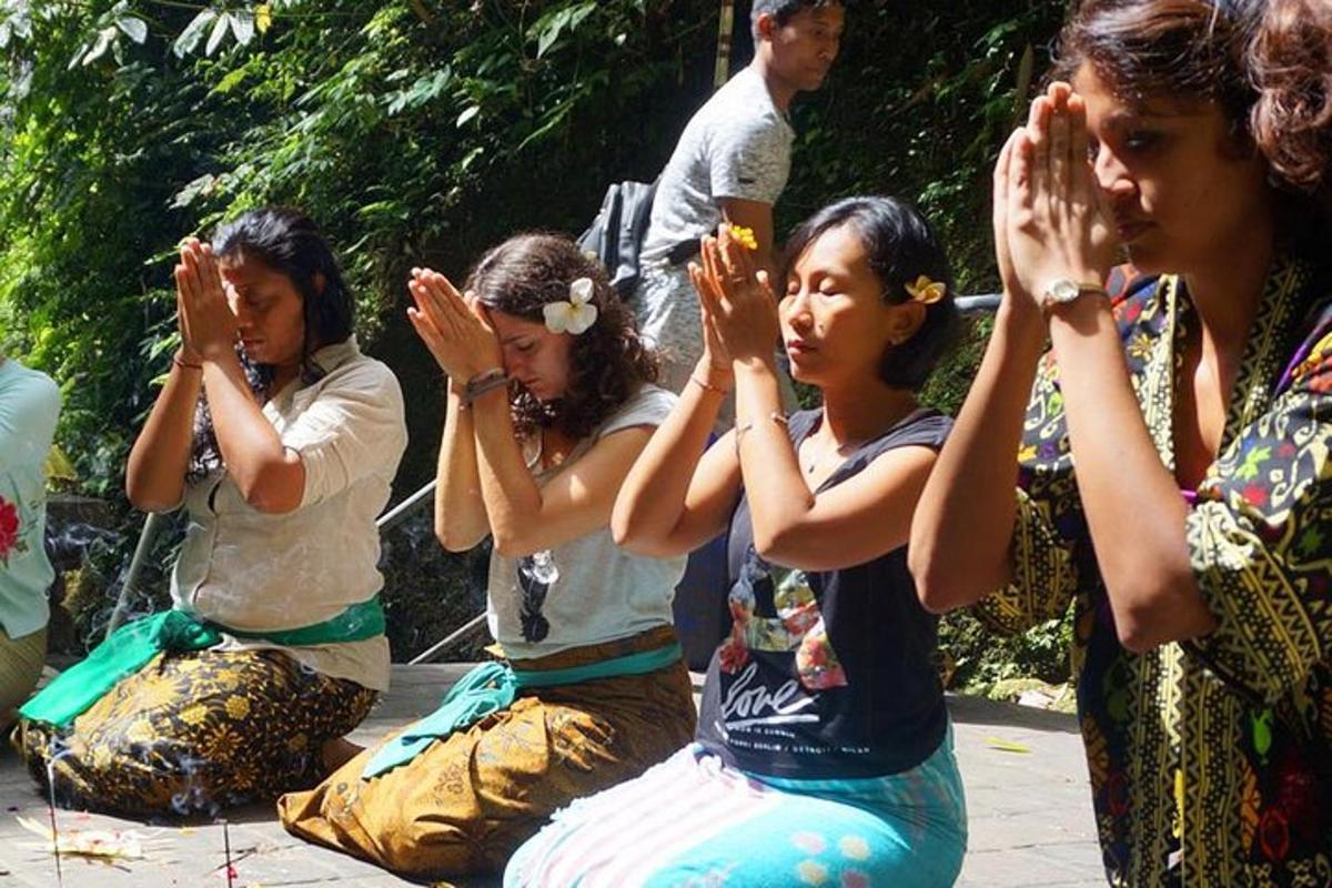 Un grupo de mujeres sentadas en el suelo con las manos en alto.