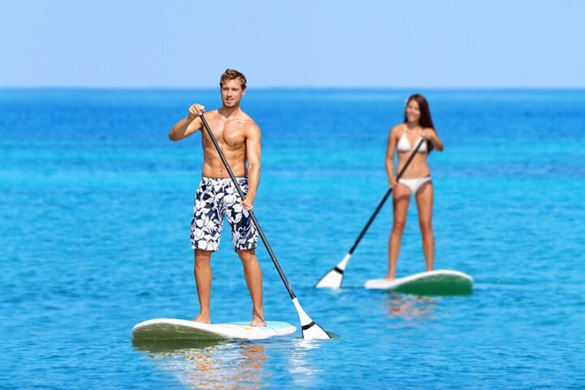a man and a woman on paddle boards in the water