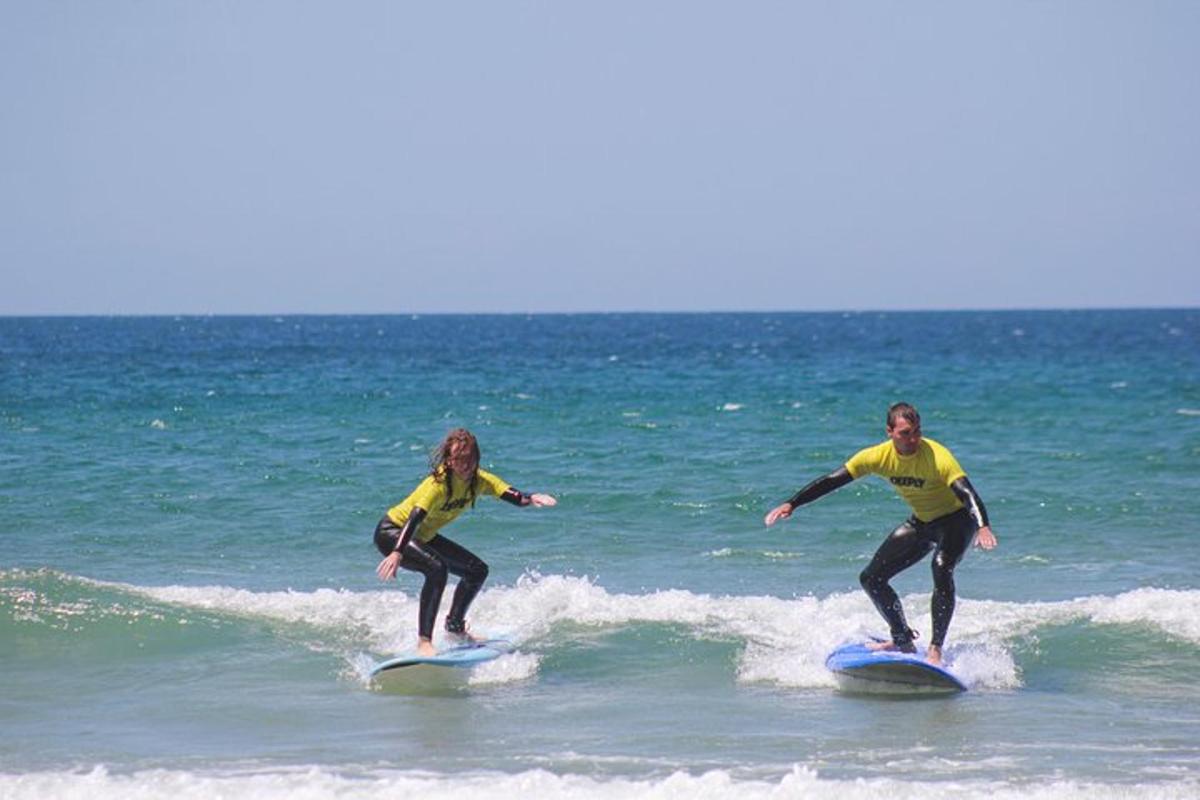 Dos personas surfeando sobre las olas en tablas de surf en el océano.