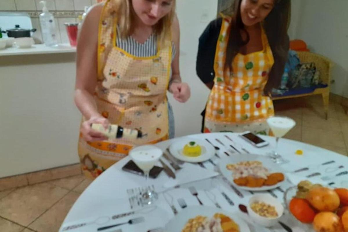 dvě ženy stojící vedle stolu s talíři jídla