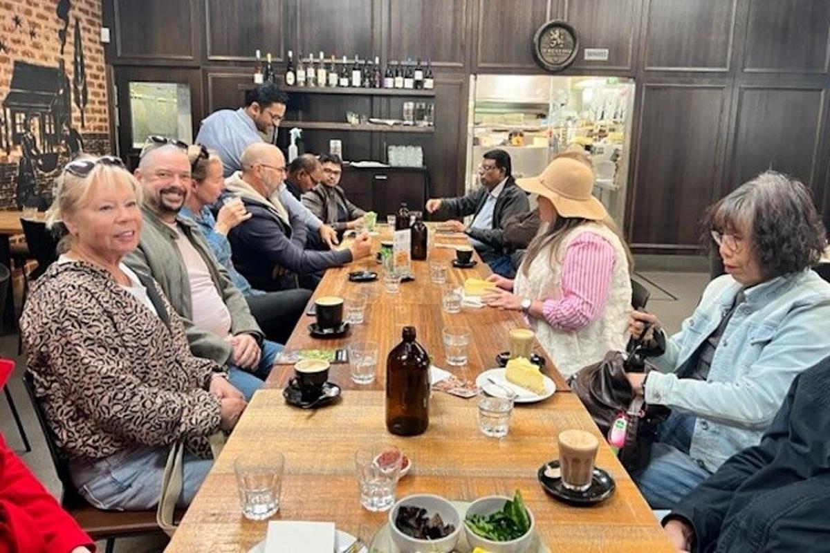 uzun bir masanın etrafında oturan bir grup insan