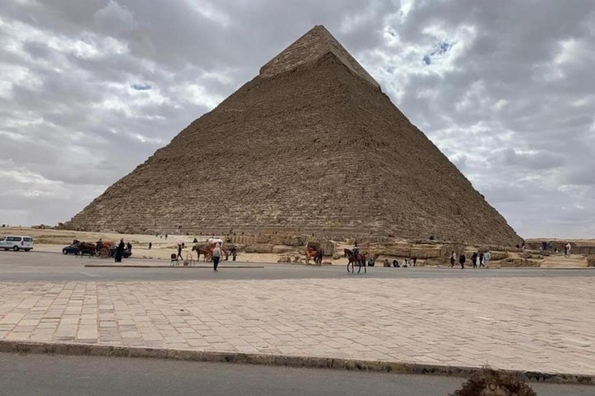 una piramide con persone e cavalli di fronte