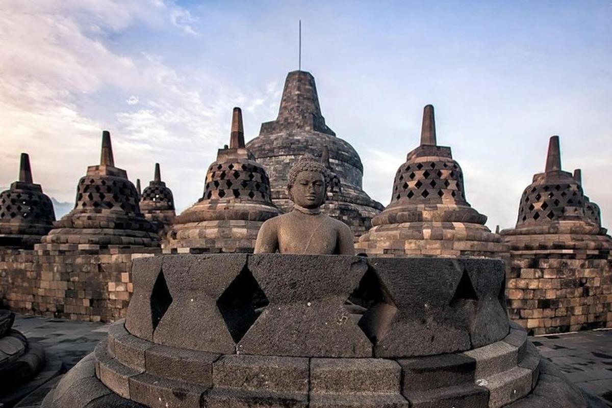 a statue sits in front of a stone building