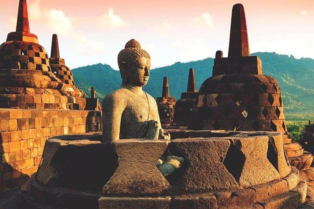 une statue assise au sommet d'un monument en pierre