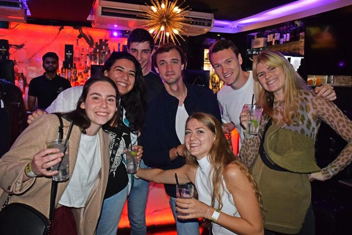 skupina lidí pózujících pro fotografii v baru