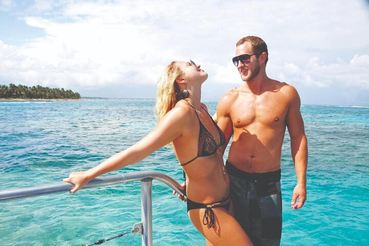 a man and woman standing on a boat in the ocean