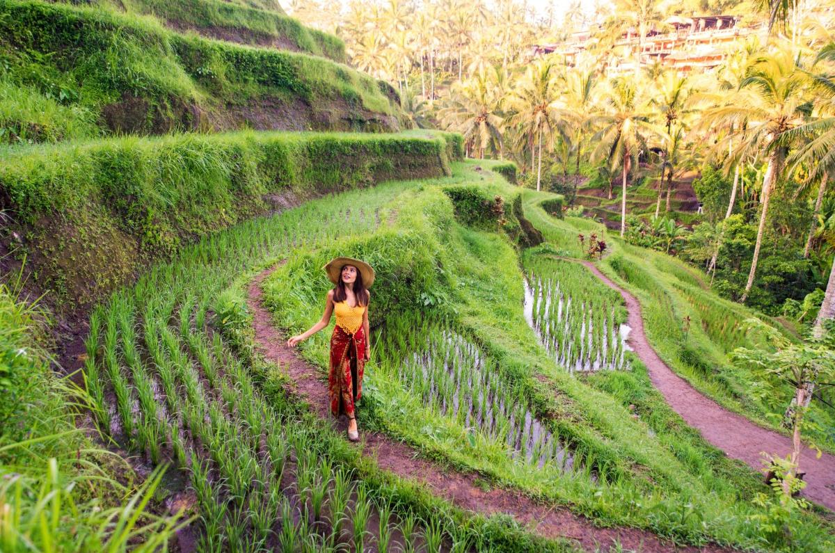 una mujer caminando por un sendero en un campo