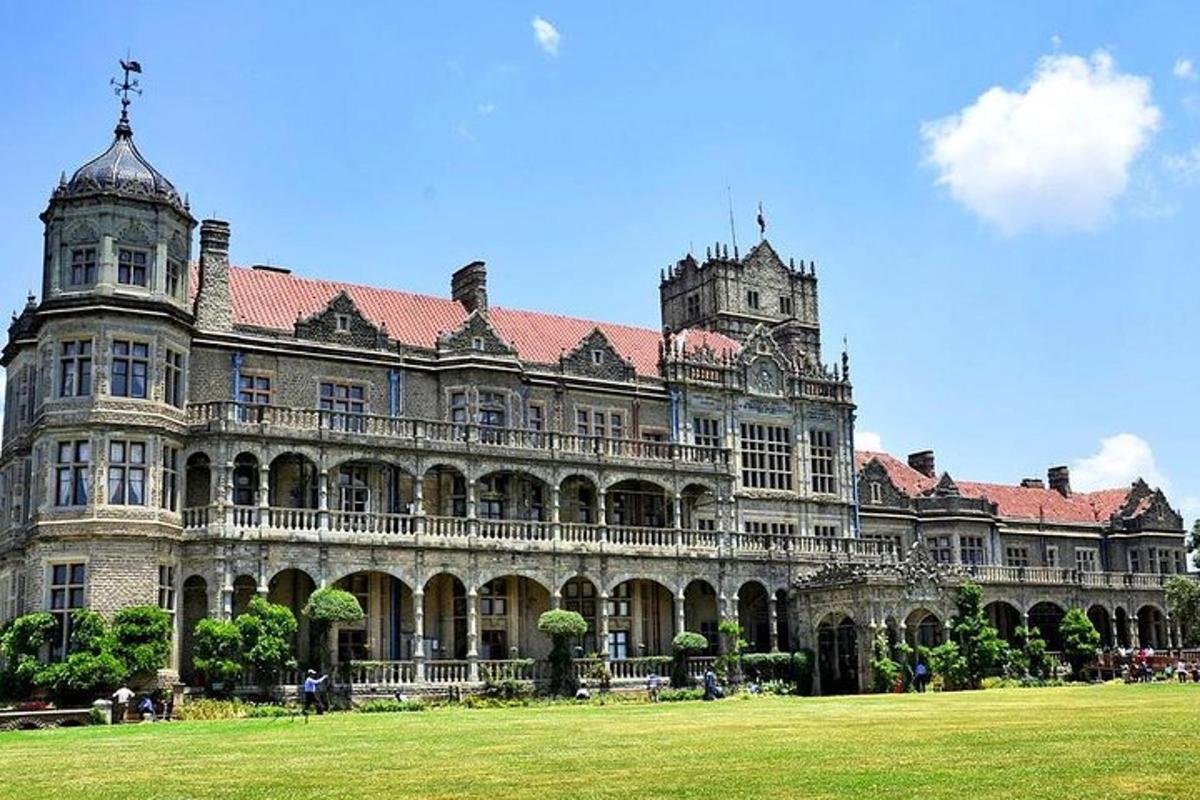 un grande edificio con un campo erboso di fronte