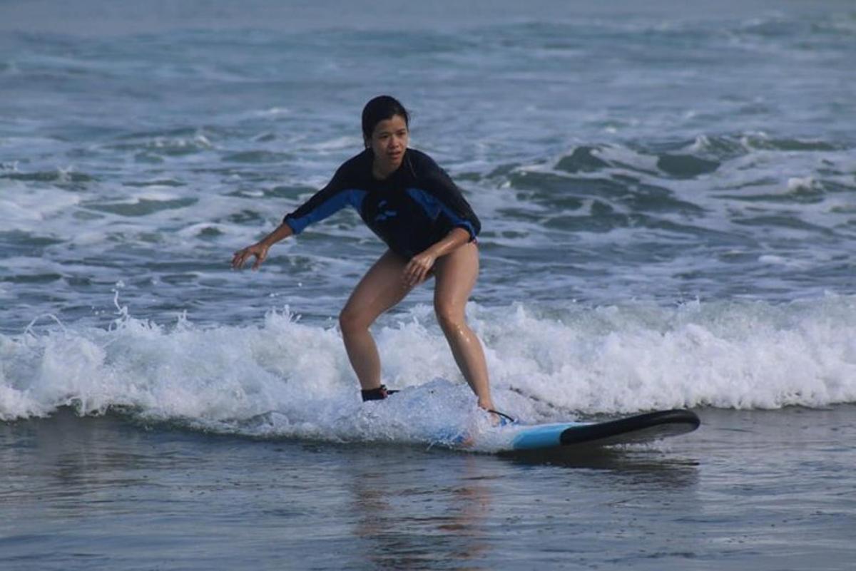 a young girl riding a wave on a surfboard in the ocean
