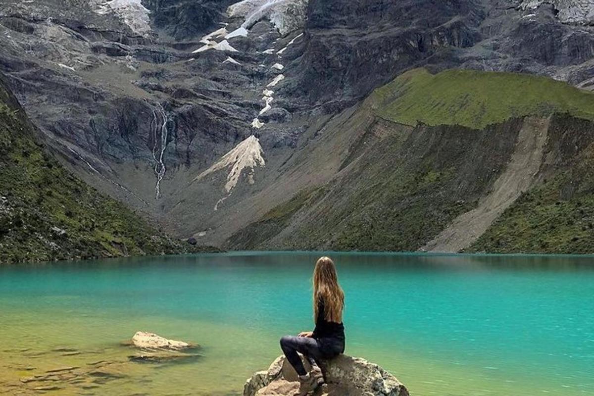 žena sedící na skále s výhledem na horské jezero