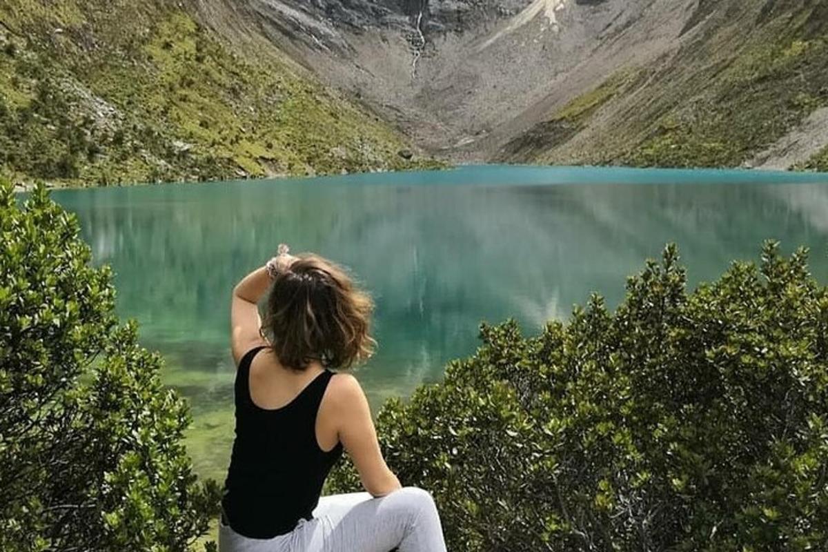 una mujer sentada frente a un cuerpo de agua