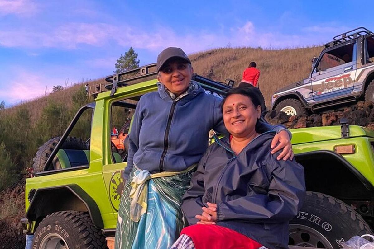 a man and a woman sitting in front of a jeep